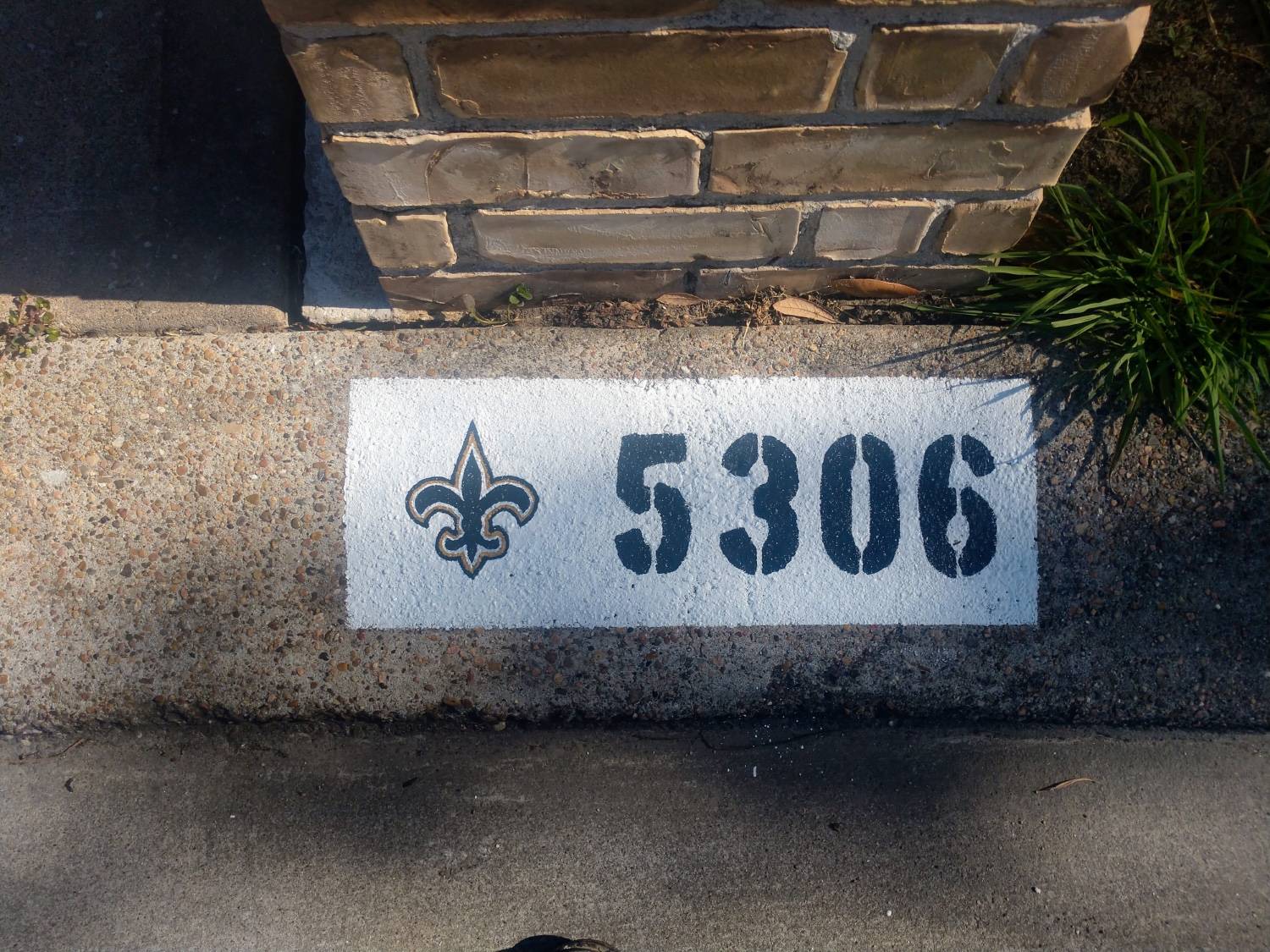 New Orleans Saints themed curb painting design on residential curb